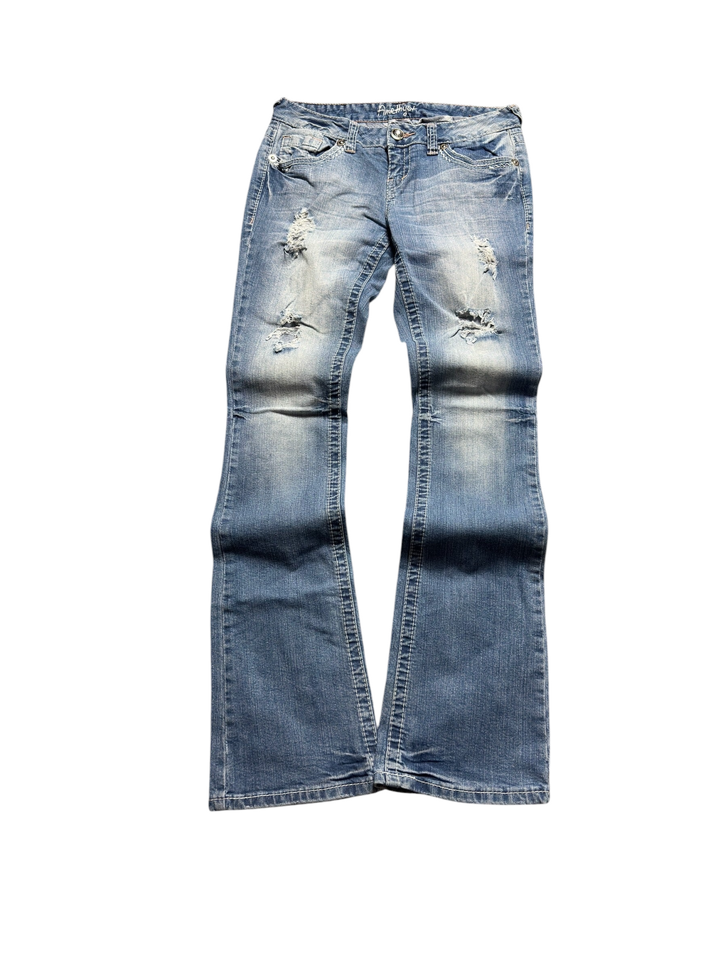 NinetyThree Amethyst medium-wash bootcut jeans with distressed front detailing and contrast stitching on a grey rug.