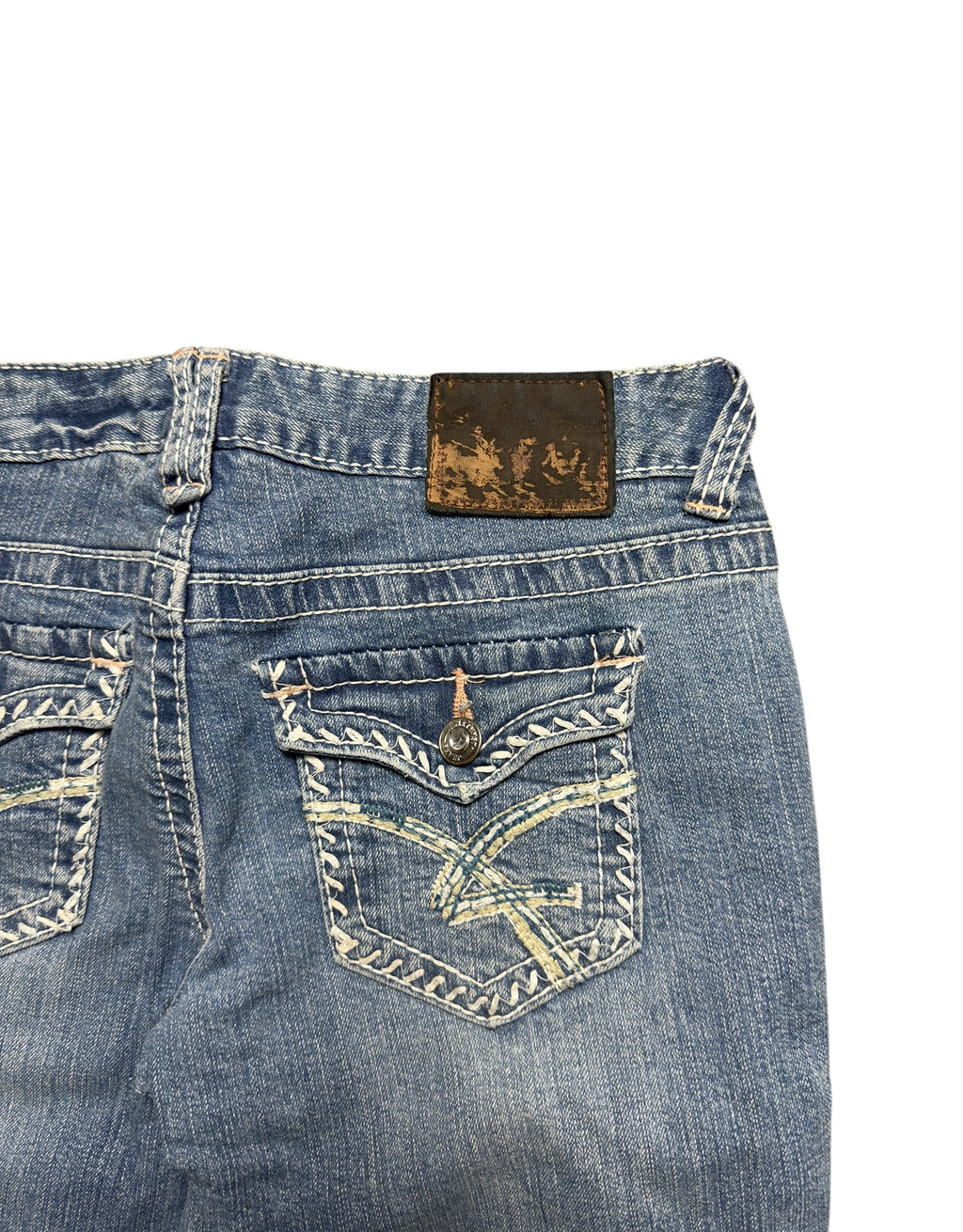 NinetyThree medium-wash bootcut jeans featuring back pockets with intricate contrast stitching and embroidery.