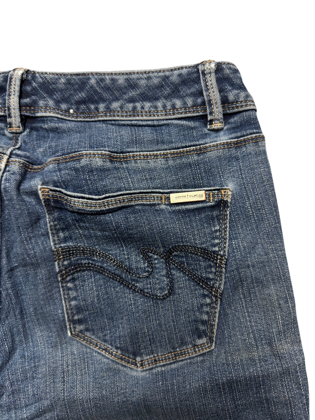 NinetyThree medium-wash blue denim jeans with signature stitching and branded metal tab on the back pocket.